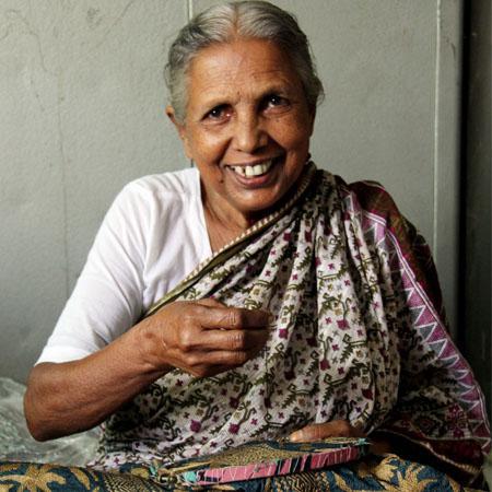 Femme artisan.  Nakski kantha fait main au Bangladesh, teinture vegetale. Commerce equitable. Hand sewn kantha, fair trade.