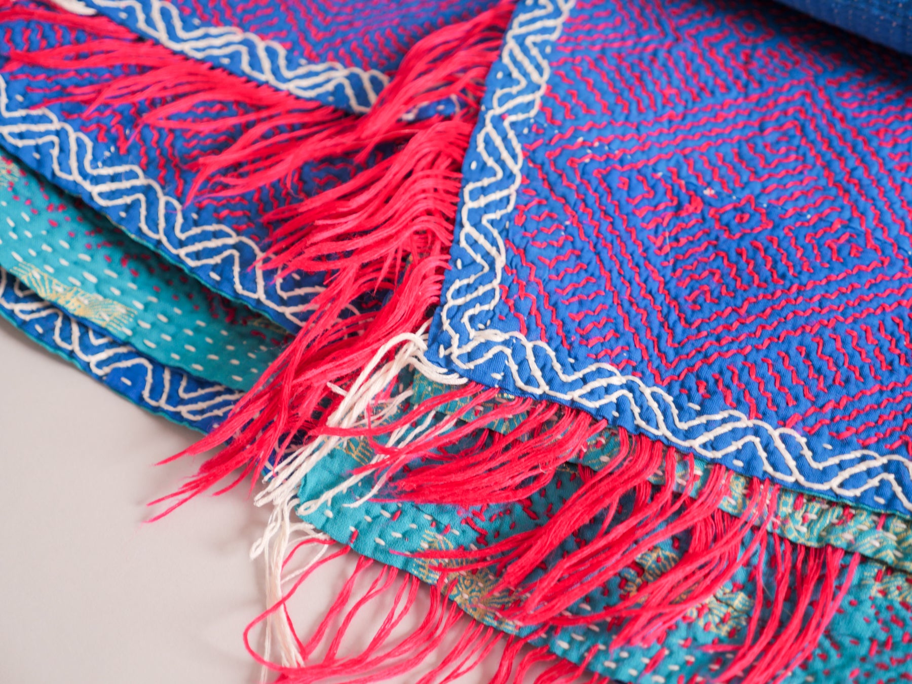 Couverture kantha brodé main, fond bleu. détail en rouge.