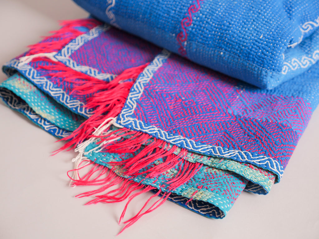 Couverture kantha brodé main, fond bleu.