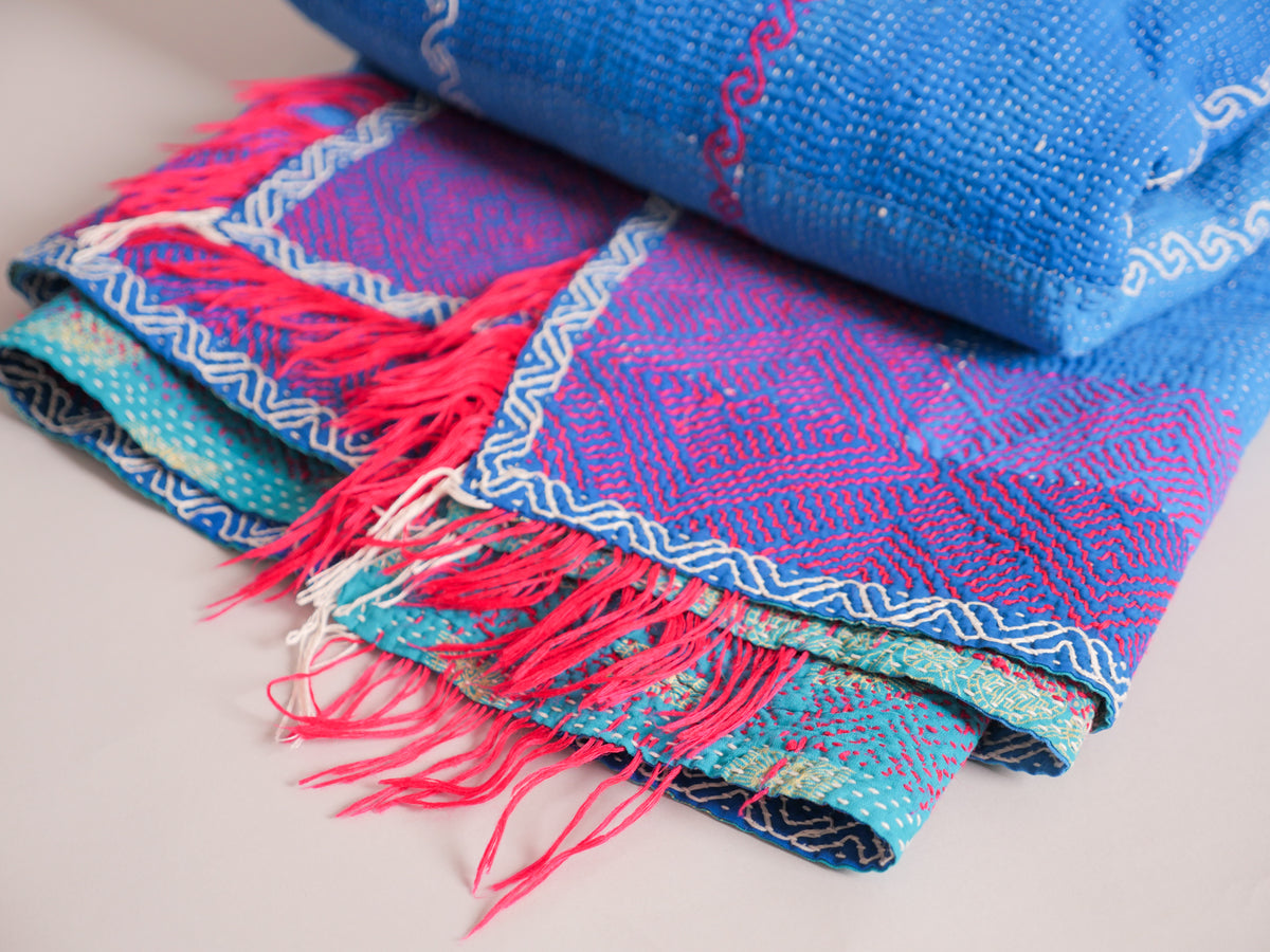 Couverture kantha brodé main, fond bleu.