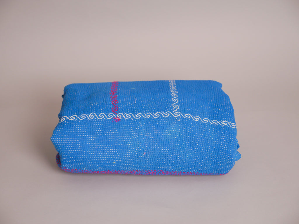 Couverture kantha brodé main, fond bleu.