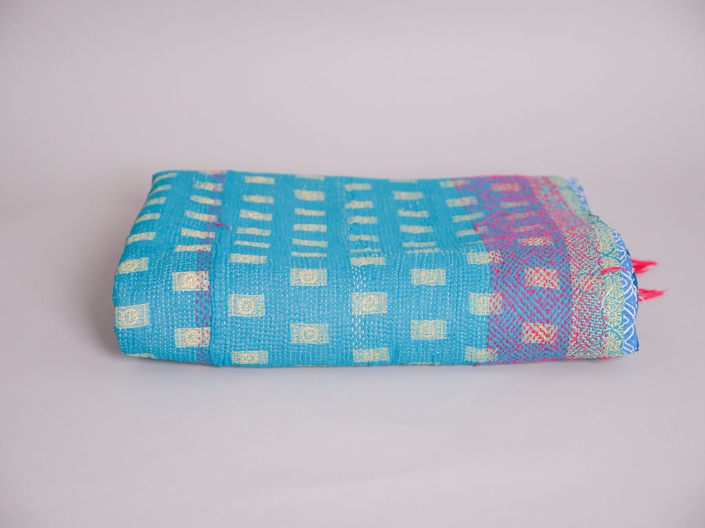 Couverture kantha brodé main, fond turquoise.