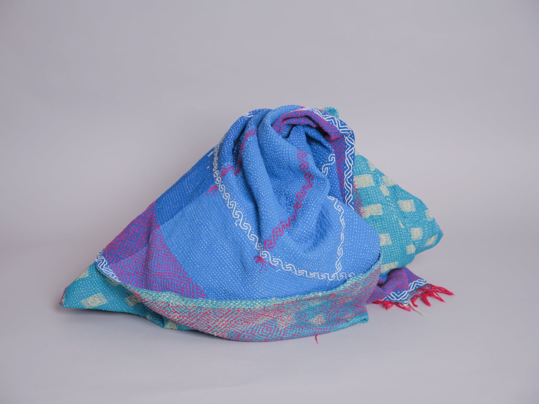 Couverture kantha brodé main, fond bleu.