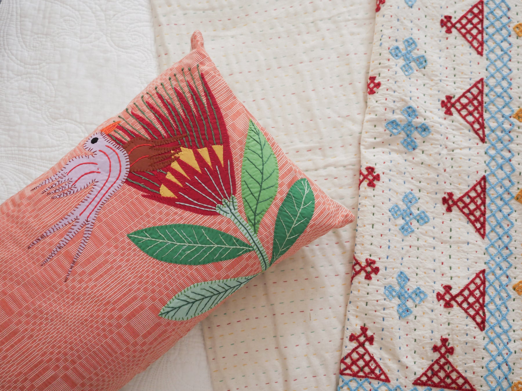 Coussin tissé main avec des brodéries en appliqué.