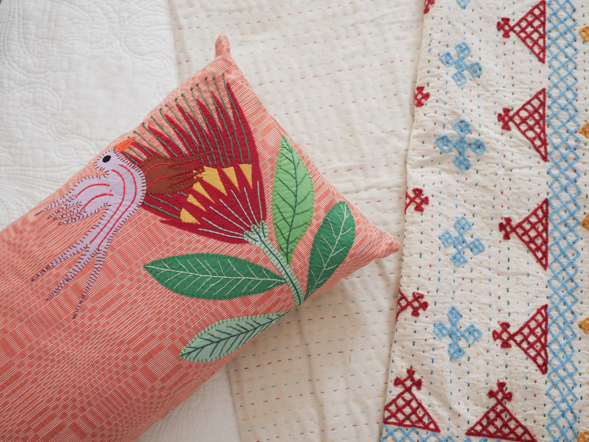 Coussin tissé main avec des brodéries en appliqué.