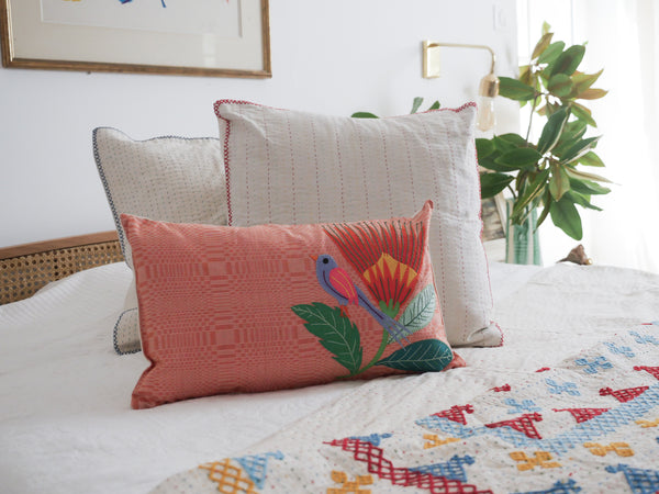 Coussin tissé main avec des brodéries en appliqué.