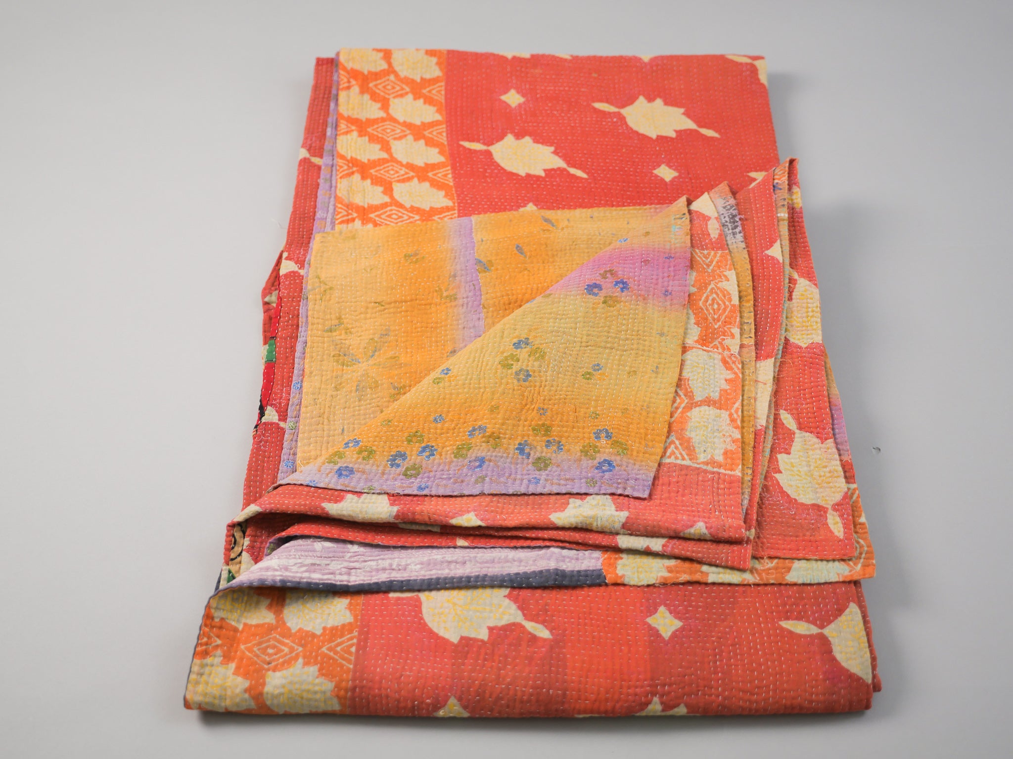 Couvre-lit kantha vintage.  Artisanat millénaire de récupération de textiles usés Le mot Kantha vient du sanscrit "Kontha" qui signifie "chiffons". Les paysannes du West Bengale assemblent plusieurs couches de vêtements usés, le plus souvent des Saris, qu'elles brodent au point pour en faire des couvertures ou des couvres-lit. 