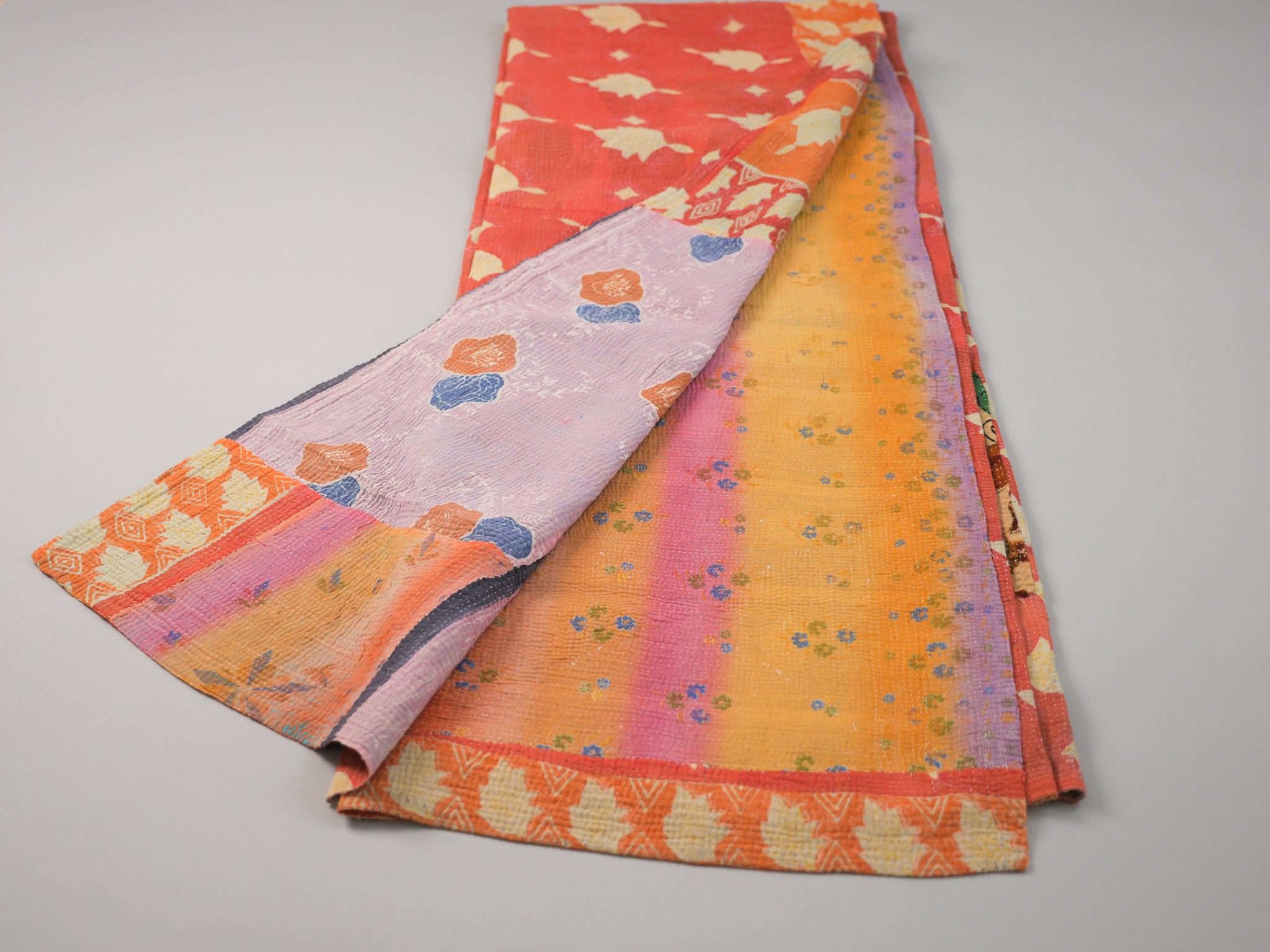 Couvre-lit kantha vintage.  Artisanat millénaire de récupération de textiles usés Le mot Kantha vient du sanscrit "Kontha" qui signifie "chiffons". Les paysannes du West Bengale assemblent plusieurs couches de vêtements usés, le plus souvent des Saris, qu'elles brodent au point pour en faire des couvertures ou des couvres-lit. 