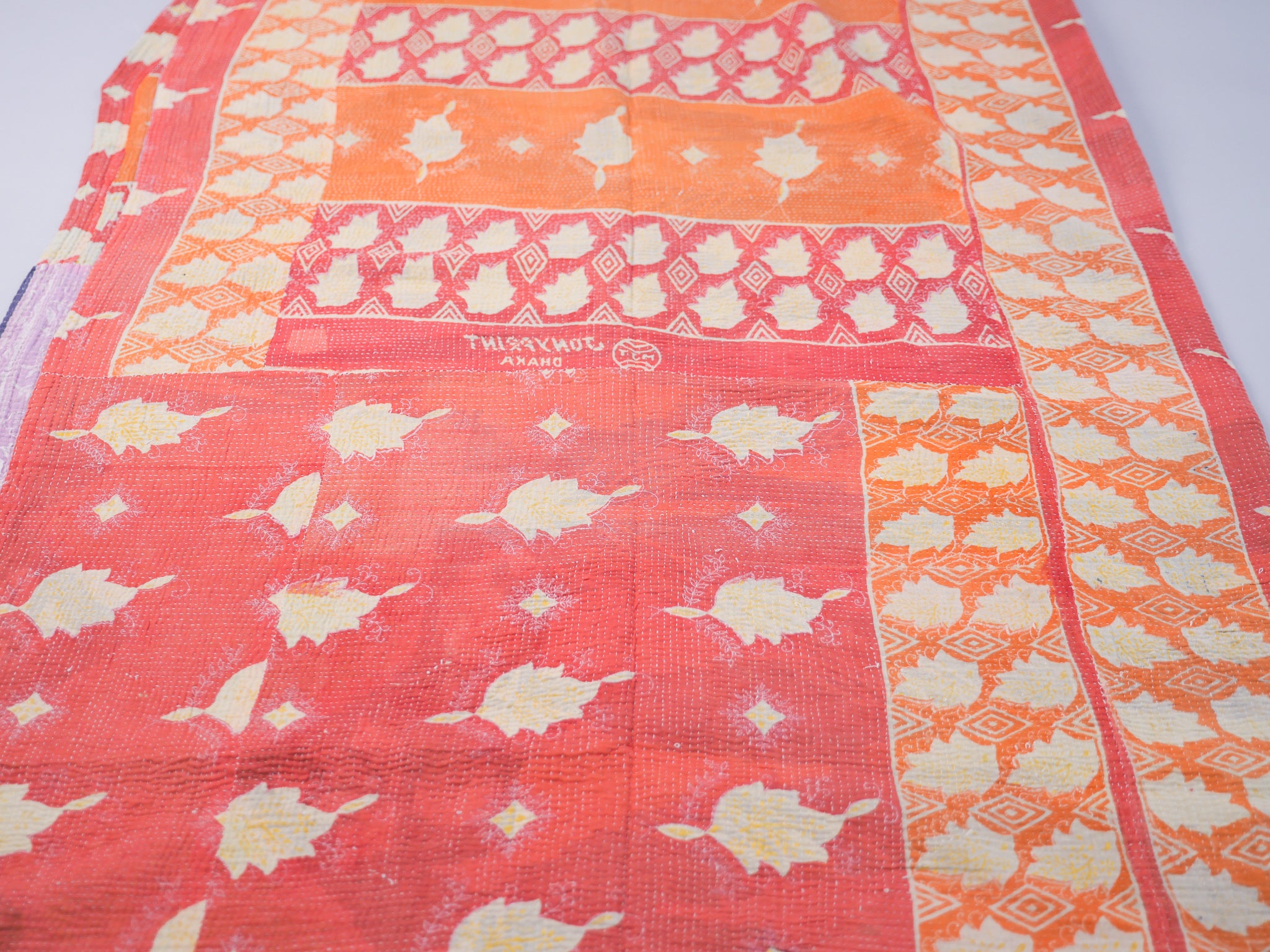 Couvre-lit kantha vintage.  Artisanat millénaire de récupération de textiles usés Le mot Kantha vient du sanscrit "Kontha" qui signifie "chiffons". Les paysannes du West Bengale assemblent plusieurs couches de vêtements usés, le plus souvent des Saris, qu'elles brodent au point pour en faire des couvertures ou des couvres-lit. 