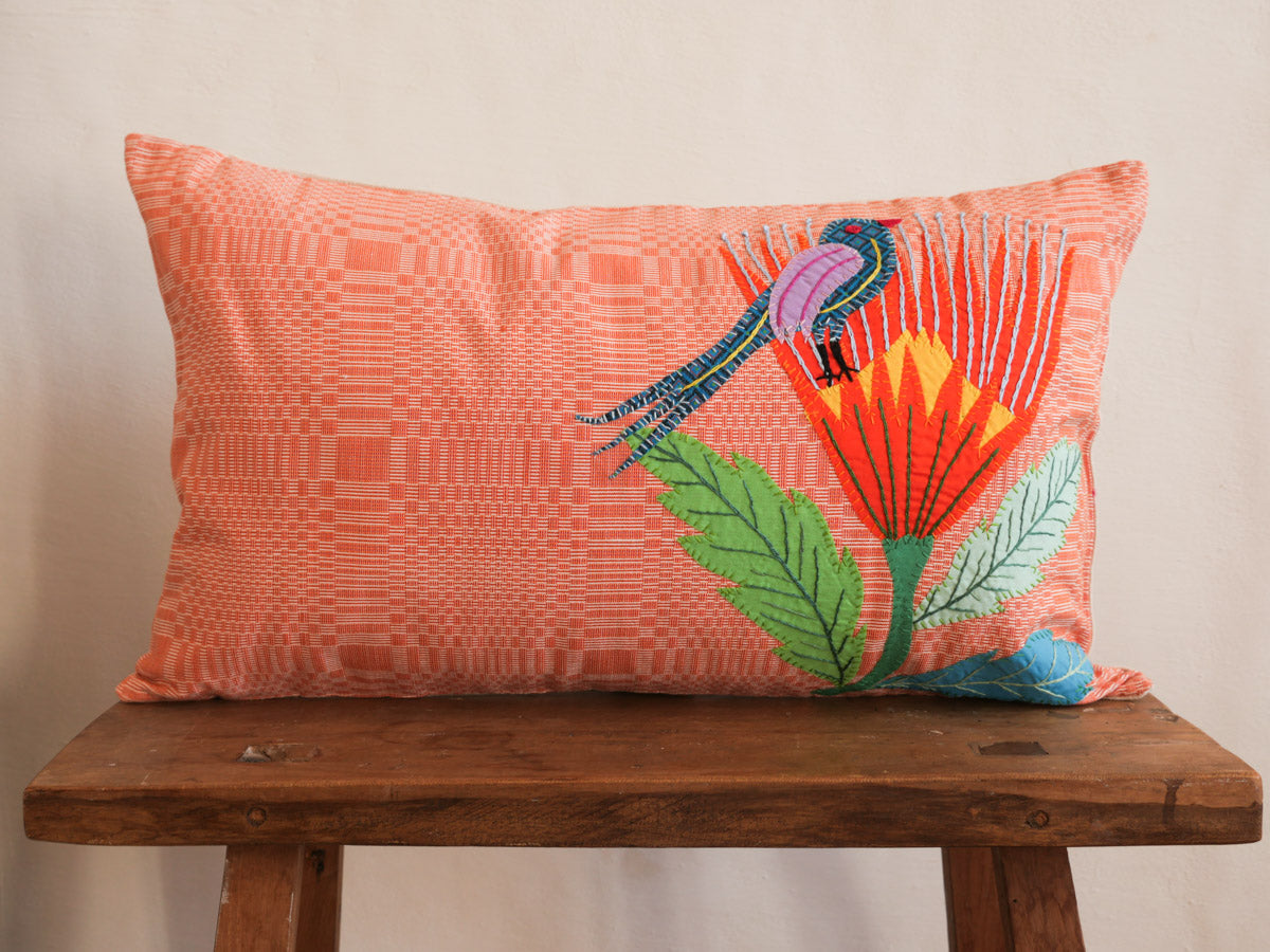 Coussin tissé main avec des brodéries en appliqué.