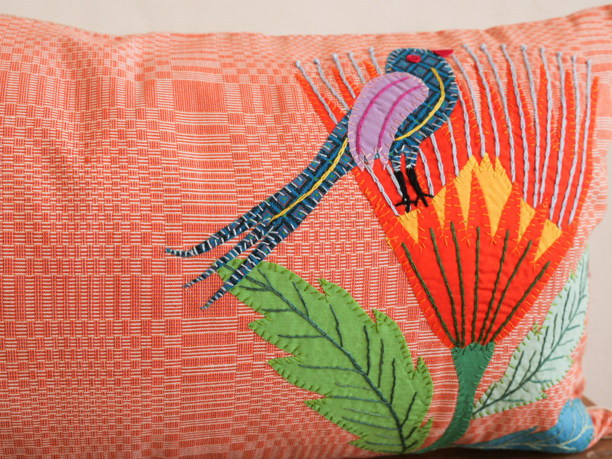 Coussin tissé main avec des brodéries en appliqué.