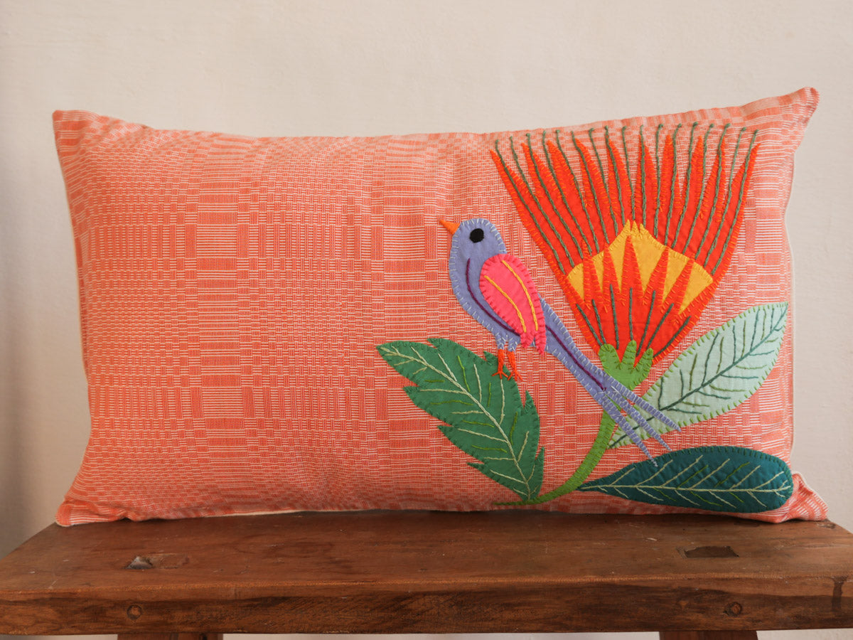 Coussin tissé main avec des brodéries en appliqué.