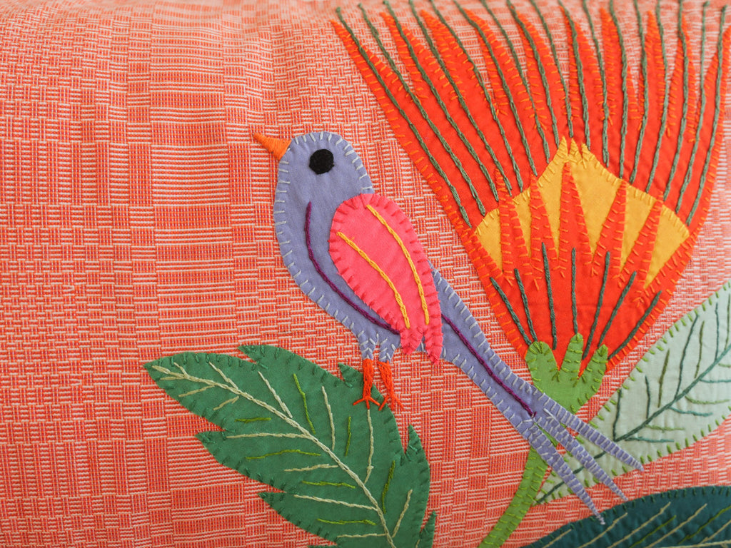 Coussin tissé main avec des brodéries en appliqué.
